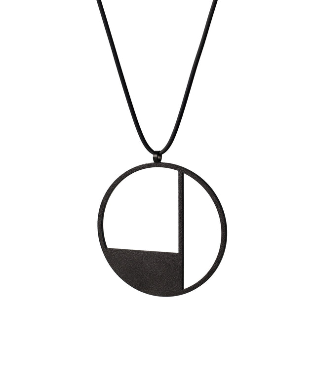 angled view of a Black circular pendant necklace on a white background