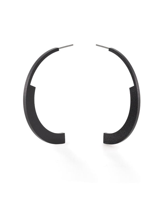 statement semi circular black hoop earrings on a white background