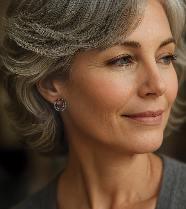 Portrait highlighting architectural earrings: precision-crafted black concrete and diamond dust in minimalist stainless steel frame.