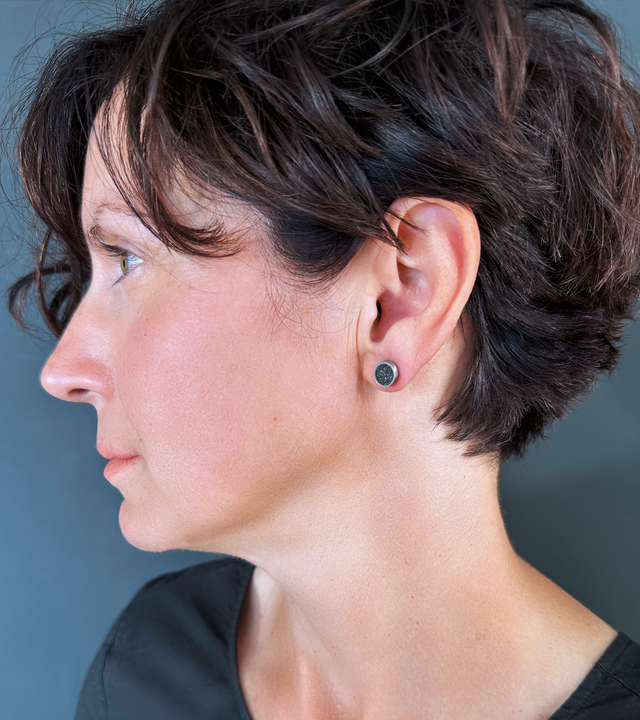 Model's ear showcases the unique minimalist earrings made with stainless steel, concrete, and stainless steel. These are inspired by the works of Bauhaus designer Herbert Bayer.