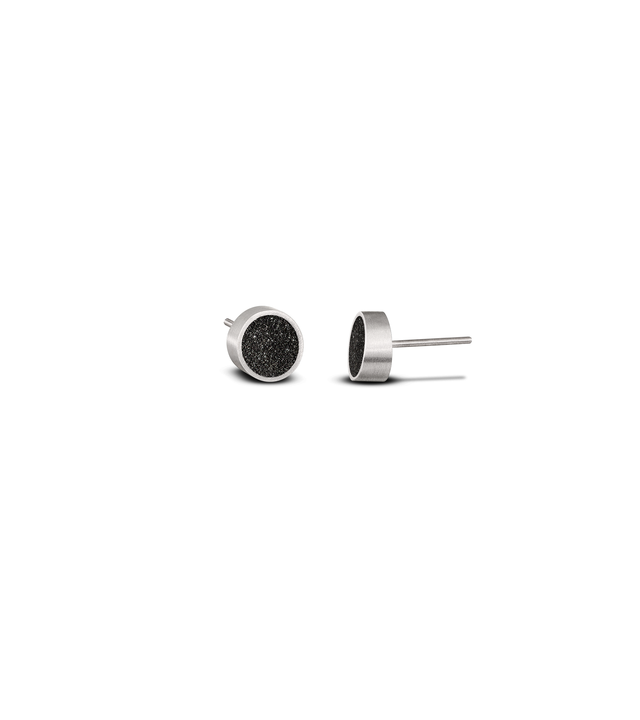 Pair of modern stainless steel stud earrings with circular black concrete-and-diamond dust inlays, featuring a minimalist geometric Bauhaus-inspired design.