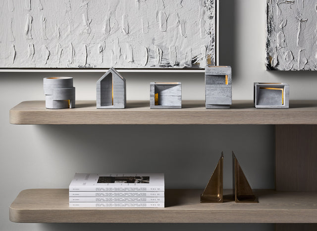 a series of 5 light gray concrete architectural concrete tealight holders from the Habitat Collection by KONZUK
