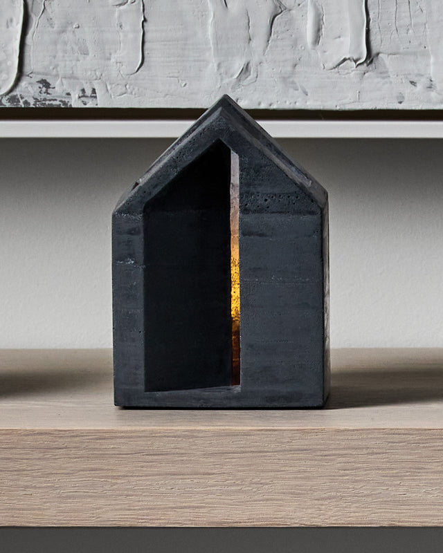 a black concrete architectural tealight holder in a house shape from the KONZUK Habitat collection