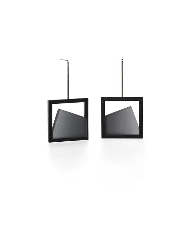 The Isla earrings highlight the beauty of light captured in resin. Each earring features a smooth gradient that shifts softly from light to dark, creating a subtle sense of depth and movement. The translucent resin reflects and diffuses light with every angle, adding a quiet luminosity to the geometric form. Elegant and modern, these earrings bring a refined balance of contrast and calm to any look. in ash gray