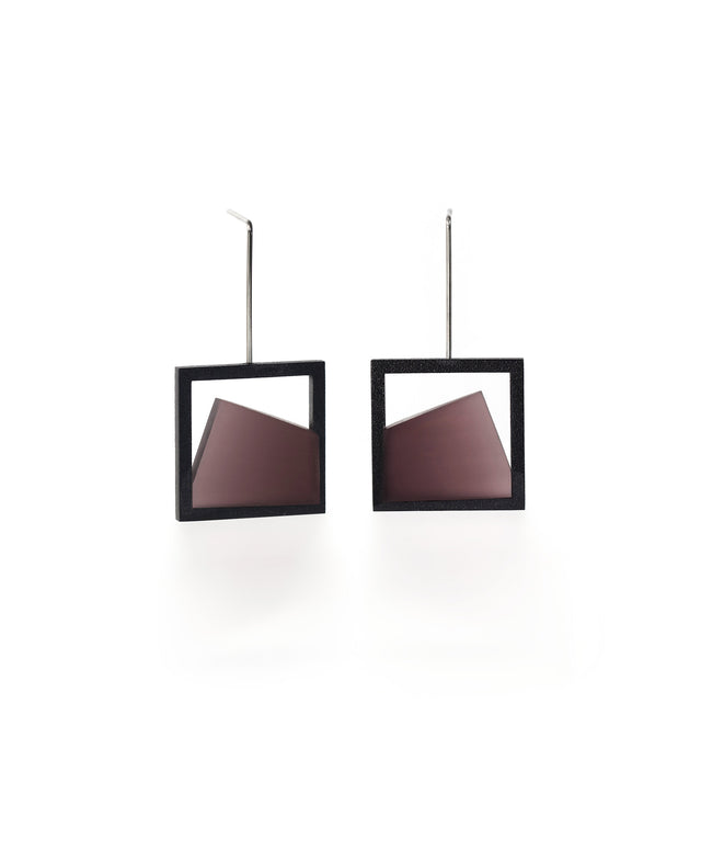 The Isla earrings highlight the beauty of light captured in resin. Each earring features a smooth gradient that shifts softly from light to dark, creating a subtle sense of depth and movement. The translucent resin reflects and diffuses light with every angle, adding a quiet luminosity to the geometric form. Elegant and modern, these earrings bring a refined balance of contrast and calm to any look. in cognac resin