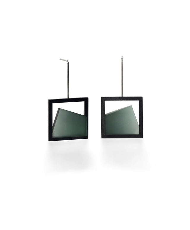 The Isla earrings highlight the beauty of light captured in resin. Each earring features a smooth gradient that shifts softly from light to dark, creating a subtle sense of depth and movement. The translucent resin reflects and diffuses light with every angle, adding a quiet luminosity to the geometric form. Elegant and modern, these earrings bring a refined balance of contrast and calm to any look. in cypress green resin