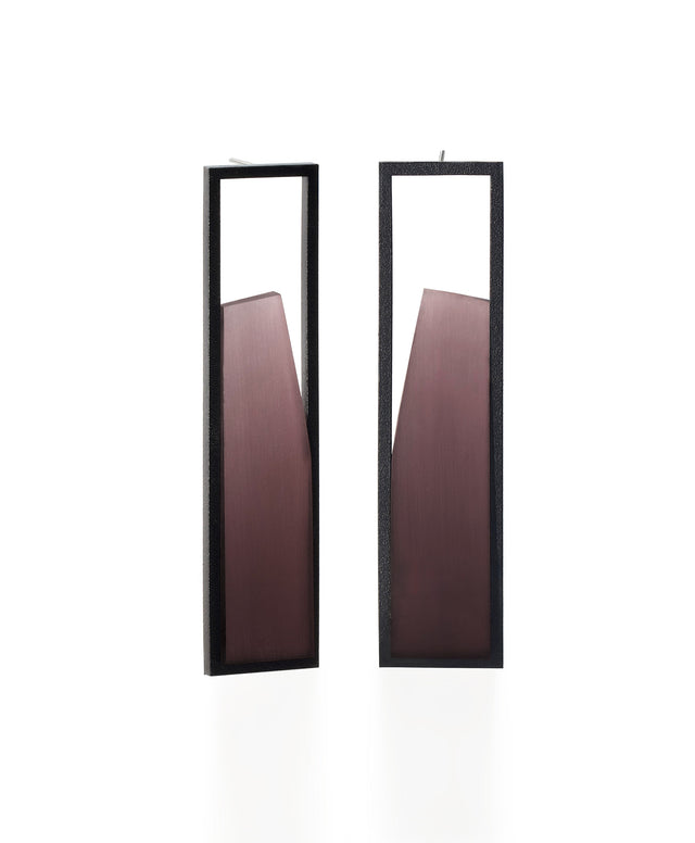 The Lucia earrings feature a sculptural interplay of shadow and light within a sleek rectangular frame. As the wearer moves, the translucent insets shift in tone deepening and softening with a turn of the head. Their geometric form captures a quiet elegance, embodying the Lumina Collection’s exploration of contrast and depth. A refined statement piece that is guaranteed to draw the eye. available in cognac