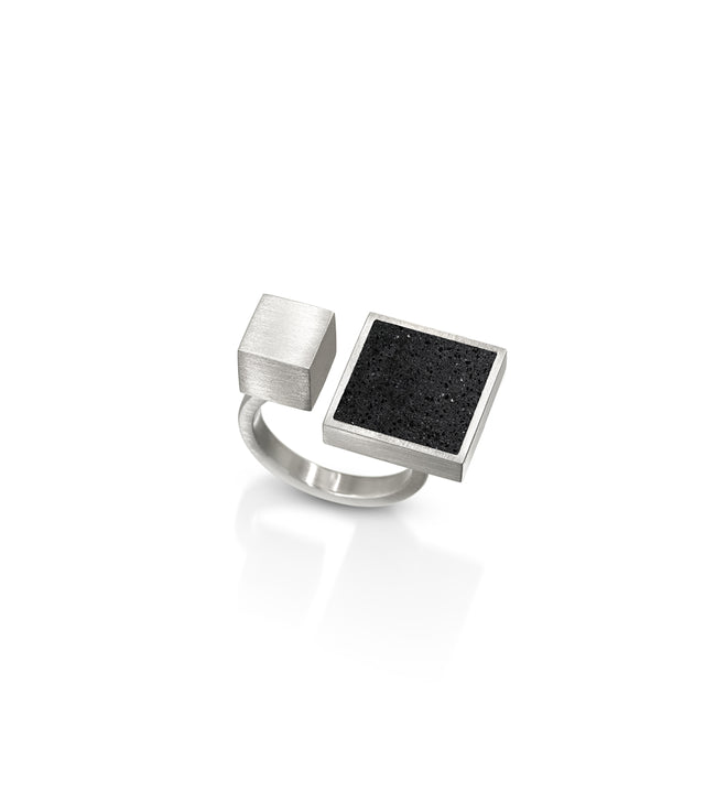 This architectural ring inspired by Theo van Doesburg combines the raw industrial beauty of concrete, set in brushed stainless steel for a striking contrast of textures. The bold geometric design brings De Stijl modernism to your everyday style, making a confident statement that bridges art and fashion while remaining surprisingly comfortable and wearable. Its durable construction ensures this sculptural piece withstands daily wear, while the interplay of matte concrete, glittering diamond dust, and soft br