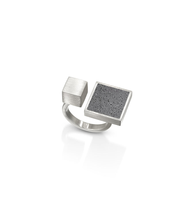 This architectural ring inspired by Theo van Doesburg combines the raw industrial beauty of concrete, set in brushed stainless steel for a striking contrast of textures. The bold geometric design brings De Stijl modernism to your everyday style, making a confident statement that bridges art and fashion while remaining surprisingly comfortable and wearable. Its durable construction ensures this sculptural piece withstands daily wear,