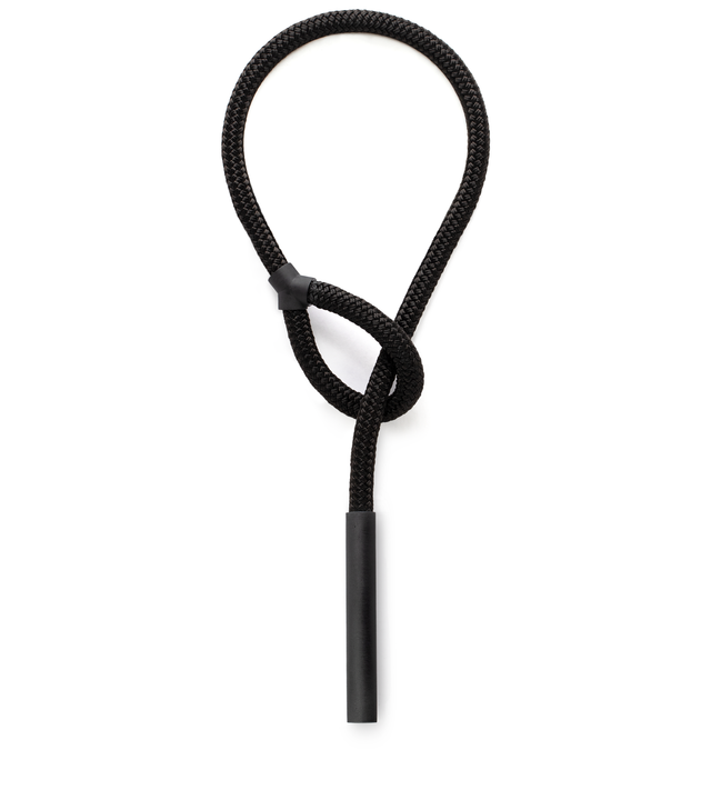 Captivating concrete pillar suspended from a double-braided black nylon rope that threads through the loop over to the other side.