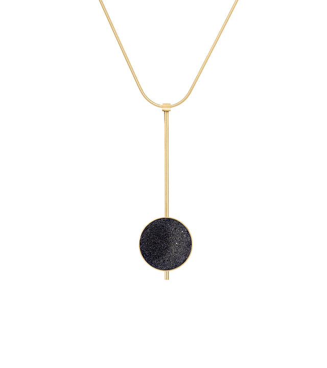 This striking Inspira necklace features a diamond dust-encrusted concrete disc set into luxurious 14 karat gold, named after the mysterious beauty of black holes. The elegant drop pendant is suspended on a sleek vertical bar and delicate omega chain, creating sophisticated movement while the sparkling texture catches light like distant stars. Timelessness is paired with modernist minimalism in this lightweight, statement-making piece that embodies cosmic wonder and transitions effortlessly from day to eveni