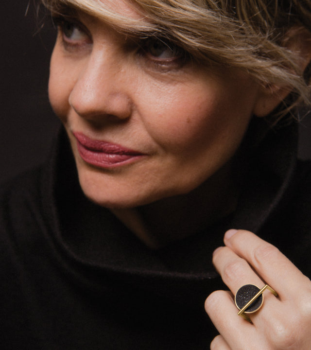 Diamond dust sparkles from inside a concrete lined solid 14k gold dome suspended from a minimalist square gold ring.