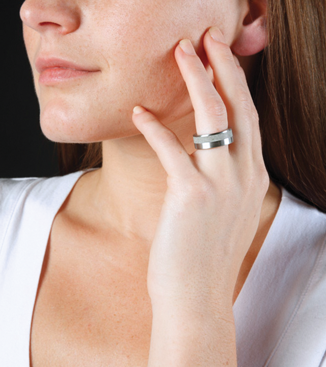 Female model wears concrete and stainless steel ring.