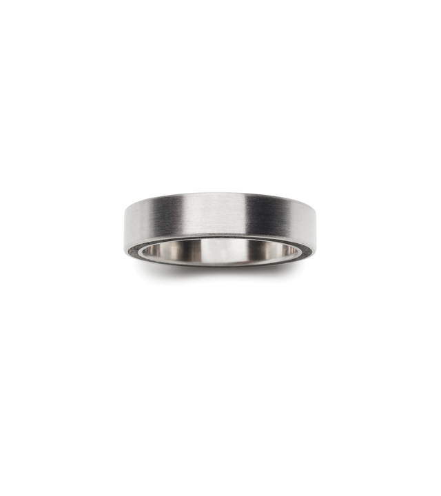 Birds eye view of a minimalist stainless steel and black concrete ring.