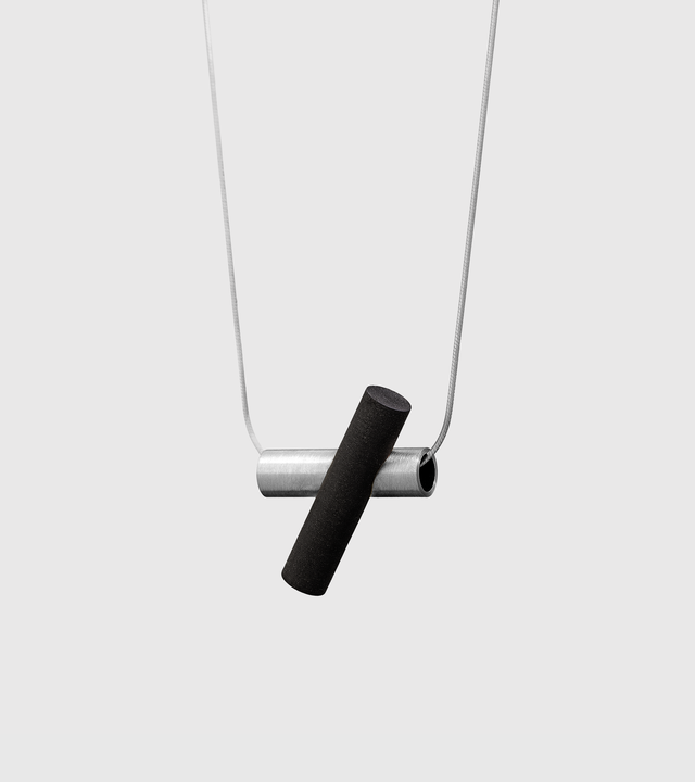 Side view of stainless steel version of Unity Plus black concrete necklace.
