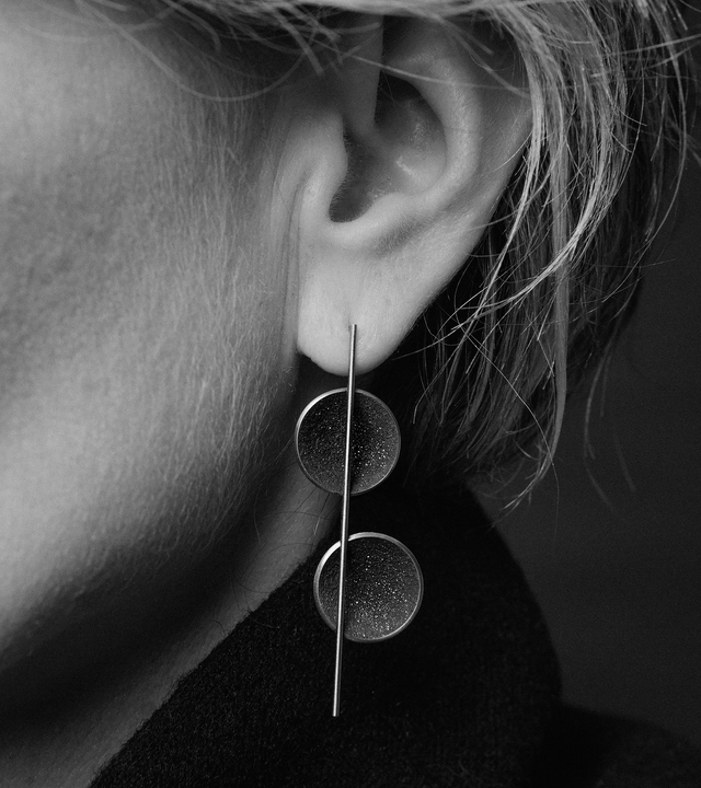 Diamond dust sparkles from inside two concrete lined stainless steel domes intersected by the bauhaus like detail of a minimalist steel post.