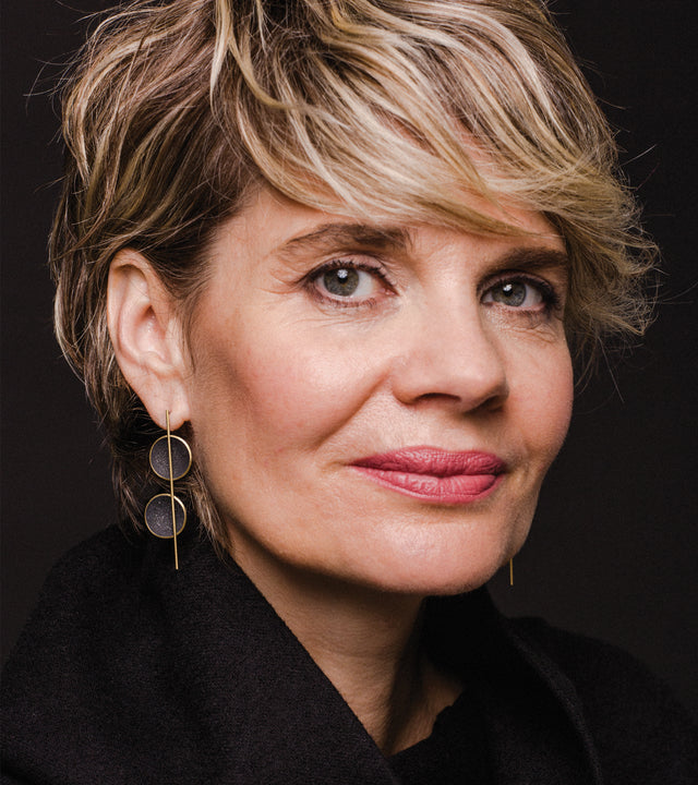 Modern jewelry featuring concrete and diamond dust set into two solid 14 karat gold domes architecturally suspended off centered from a vertically orientated gold post.