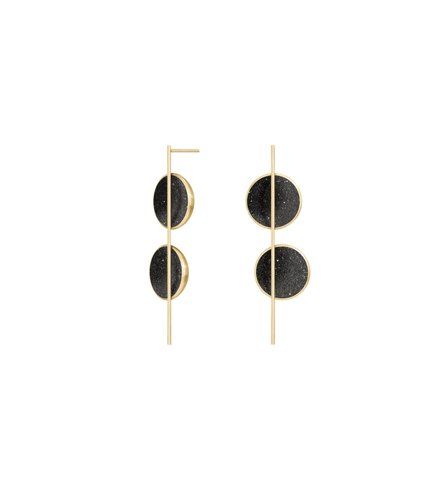 The sparkle of diamond dust infused concrete lines two solid 14 karat gold domes intersected by a thin vertically orientated gold post.