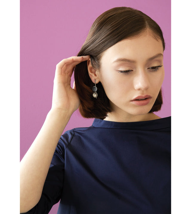 Bauhaus inspired Freya Minor earrings feature two smaller double solid 14 karat gold domes, one lined with diamond dust infused black concrete both architecturally supported an elegant hanging gold post.