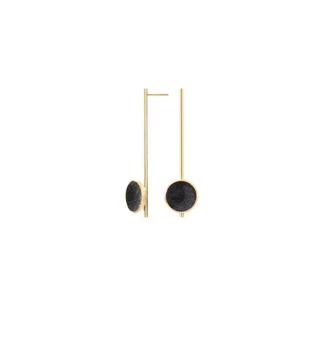A pair of 14k gold earrings with black concrete lined gold domes and diamond dust accents.