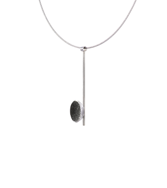 Side view of the Inspira Minor necklace featuring authentic diamond dust embedded into a concrete lined stainless steel dome architecturally positioned onto a suspended minimalist steel post.