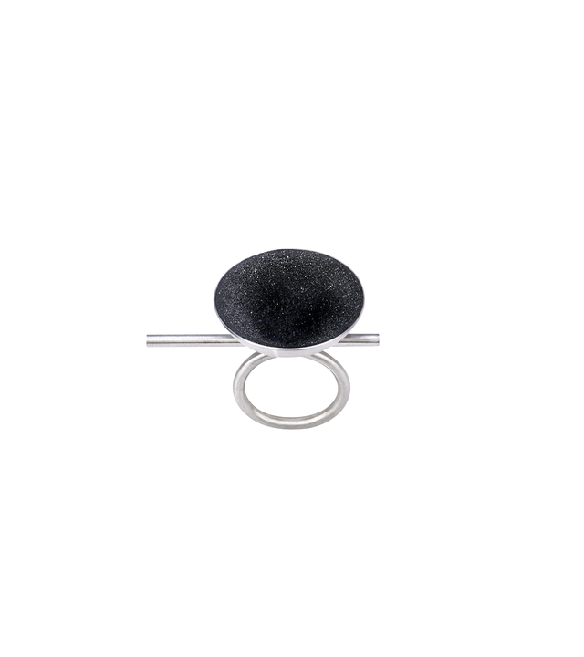 Top view of the Juno Major ring features with diamond dust infused concrete lining a stainless steel dome perched off center of its supporting steel rod round steel ring.