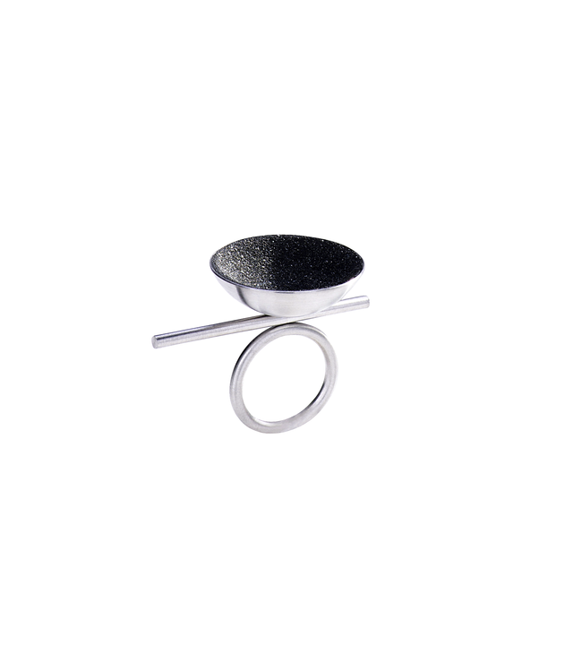 Juno Major ring features with diamond dust infused concrete lining a stainless steel dome perched off center of its supporting steel rod round steel ring.