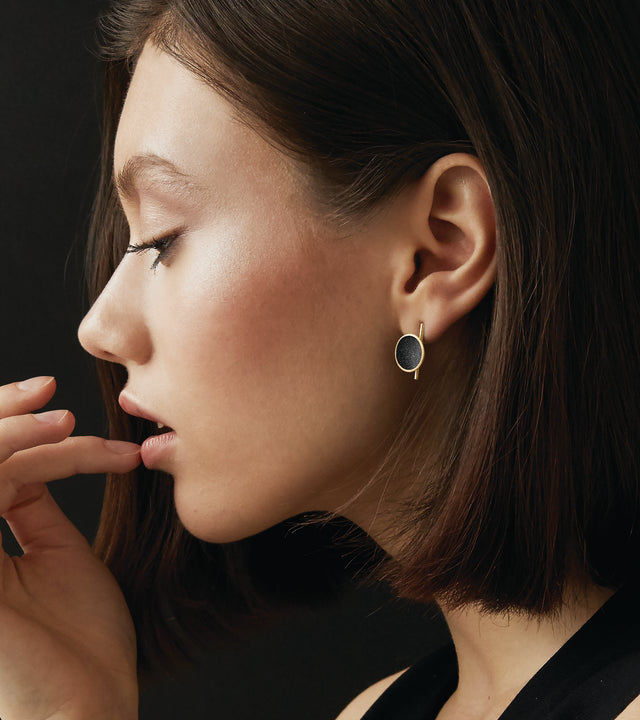 Imagine the path to Jupiter forged by the spacecraft Juno…Measuring only 19.5mm x 13mm, these small Bauhaus inspired black dome earrings are set in brushed 14 karat solid gold, a subtle shimmering detected in the wells of velvety concrete infused with diamond dust. Elegance and timelessness are paired with modernist minimalism. An expression of romance and imagination with high design.