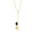 Side view of the modern Freya Minor necklace features two double solid 14 karat gold domes, one lined with diamond dust infused black concrete both architecturally supported an elegant hanging 14k gold post.