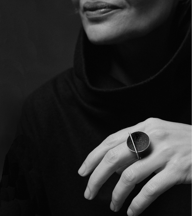 The sparkle of diamond dust infused concrete lines a stainless steel dome suspended from a minimalist square steel ring.