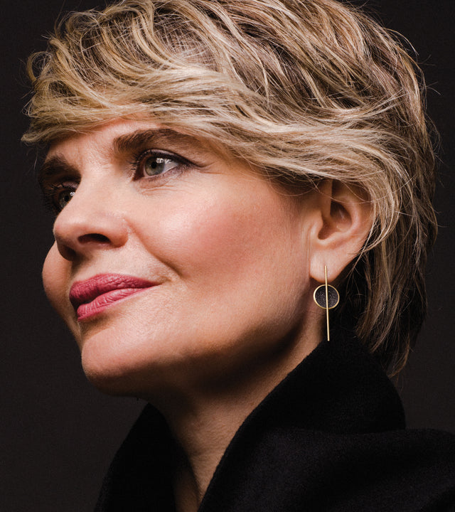 The sparkle of diamond dust infused concrete lines a solid 14 karat gold dome intersected by a thin vertically orientated gold post.