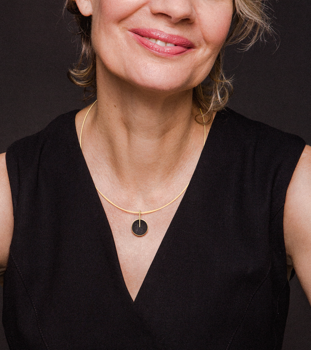 This elegant necklace features a diamond dust-encrusted concrete dome in warm 14k gold with a sleek vertical bar design that creates sophisticated geometric balance. The compact size makes it perfect for everyday layering or standalone wear, while the sparkle of diamond dust against the dark concrete offers subtle luxury that catches the light beautifully. Suspended on a delicate snake chain, this lightweight piece combines industrial materials with refined craftsmanship for effortless contemporary style.