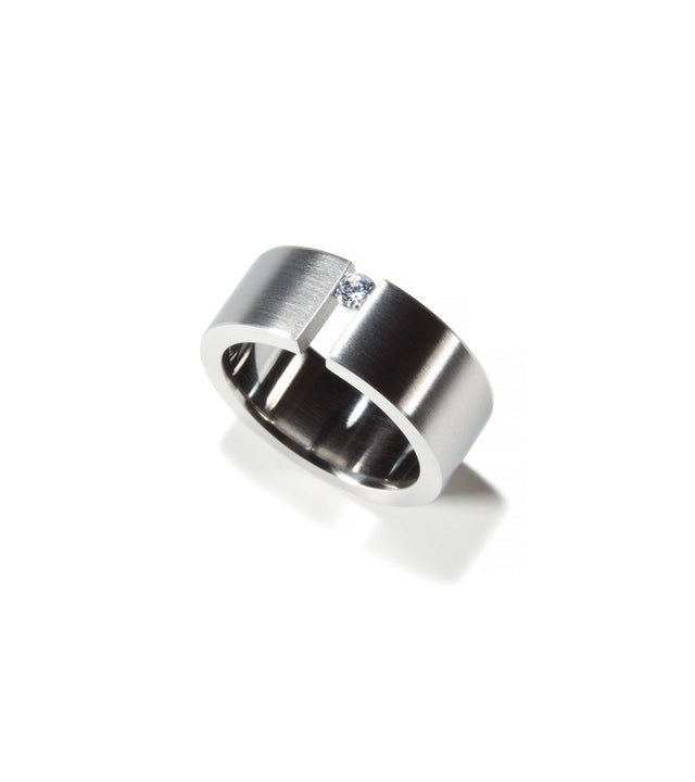 Top view engagement ring with .10ct diamond tension set into wide stainless steel band.