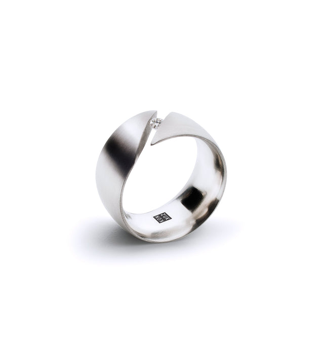 A stainless steel engagement ring with a single Canadian diamond set in a tension mount on a curved band, with a brushed finish on the outside and a polished inside.