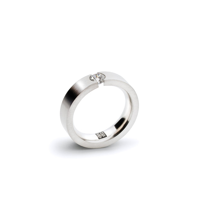 A sleek engagement ring featuring a .30ct diamond tension set in a stainless steel or platinum band.