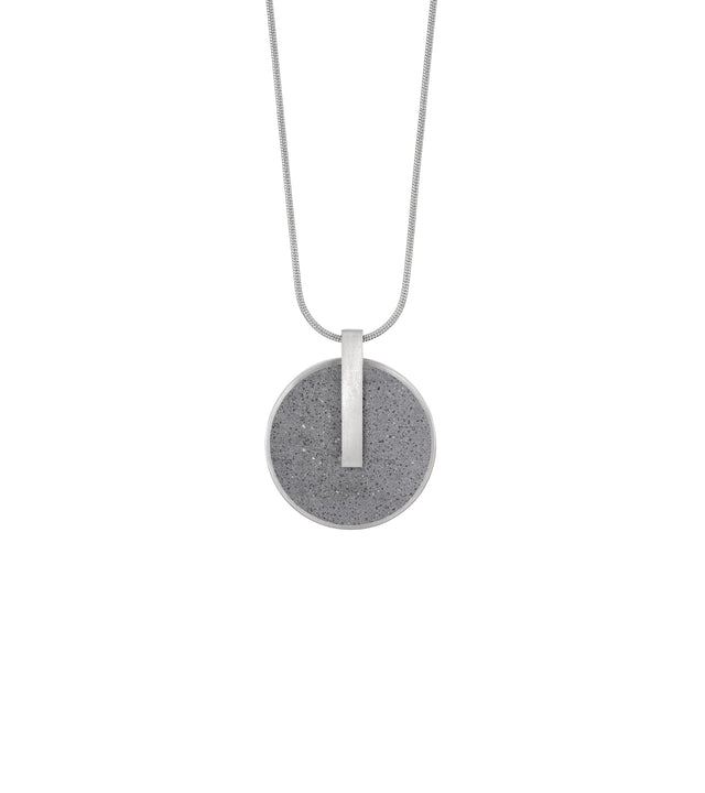Memento Eternal locket with concrete set into circular stainless steel framework.