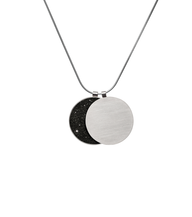 Classic and bold in style, this overlapping double pendant in concrete, diamond dust and stainless steel hangs centred creates the phases of the moon depending on how the piece hangs.