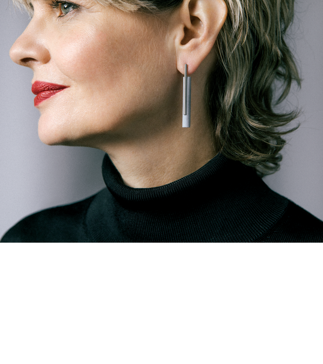 These minimalist Unity Tandem earrings are highlighted by a brushed stainless steel rod positioned in front of a small natural or black concrete cylinder.