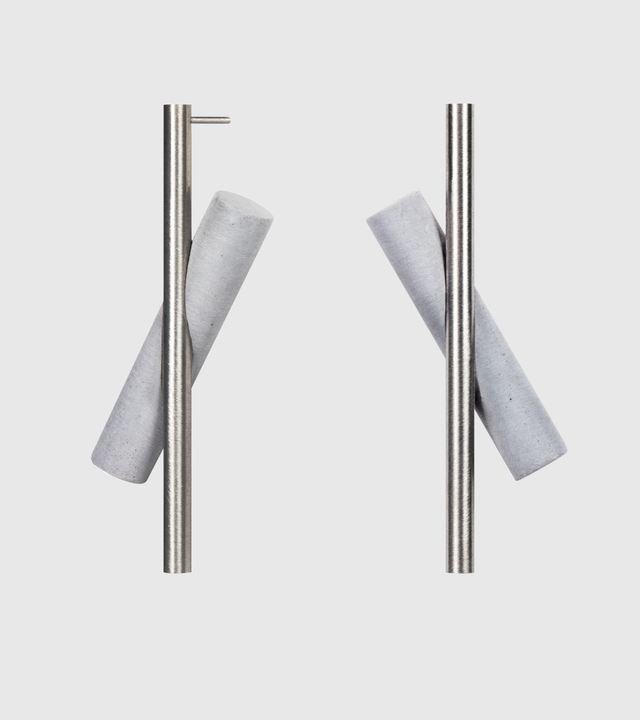These elongated drop earrings make a bold statement with their dramatic length and striking geometric design, featuring contrasting grey concrete with brushed stainless steel that create dynamic visual movement. The substantial size commands attention while remaining surprisingly lightweight and comfortable. Their modern, architectural aesthetic pairs beautifully with both minimalist and bold fashion choices, adding an instant touch of contemporary elegance.