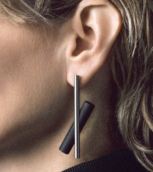 These elongated drop earrings make a bold statement with their dramatic length and striking geometric design, featuring contrasting concrete with brushed stainless steel that create dynamic visual movement. The substantial size commands attention while remaining surprisingly lightweight and comfortable. Their modern, architectural aesthetic pairs beautifully with both minimalist and bold fashion choices, adding an instant touch of contemporary elegance.