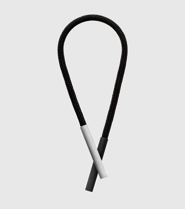 A Unity x 17 necklace featuring two intersecting concrete cylinders with a black double braided nylon rope and rare-earth magnets.