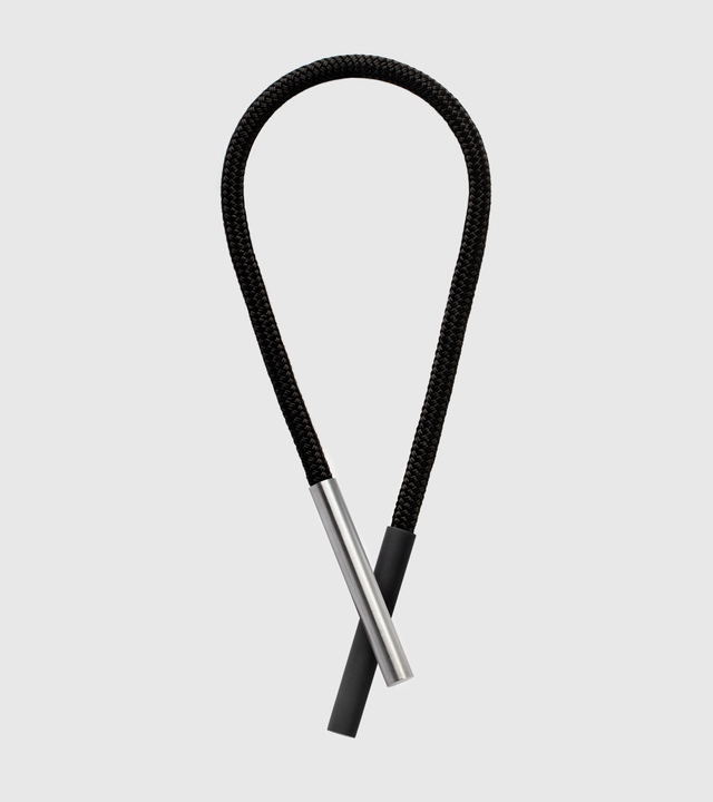 This striking statement necklace features sleek concrete and stainless steel elements suspended from a black cord, creating a bold yet minimalist aesthetic that draws the eye to the neckline. The innovative design uses rare earth magnets to attach the concrete and stainless steel components, allowing for versatile styling and effortless wear while ensuring secure placement.