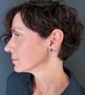 Model with short hair wearing earrings inspired by Josef Albers' "Homage to the Square" Bauhaus series. These earrings showcase harmonious geometric shapes and material combinations, reflecting Albers' meticulous attention to detail.