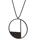 side view of KONZUK Artus circular Necklace with a black and white geometric pendant on a rubber cord