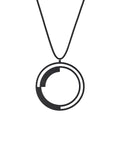 This pendant introduces curves into the collection's vocabulary, creating a rhythmic balance as the solid forms anchor the circular form while leaving generous arcs of openness between them. The double-ring structure adds depth and layering, transforming the simple circle into a study of rotation and counterbalance. It's a dynamic composition that suggests movement and continuity, as if the solid arcs are in gentle orbit within their circular bounds.