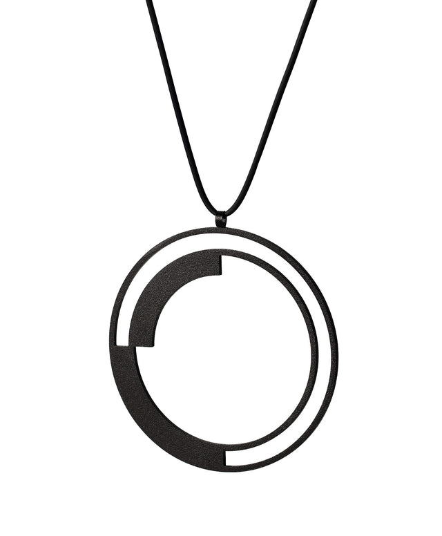 side view of a large statement necklace from the KONZUK Artus collection featuring a round geometric form of black powder coated stainless steel.
