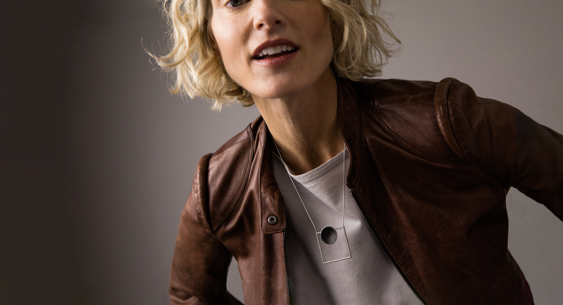 Model wears stainless steel necklace set with concrete embedded with diamond dust.  