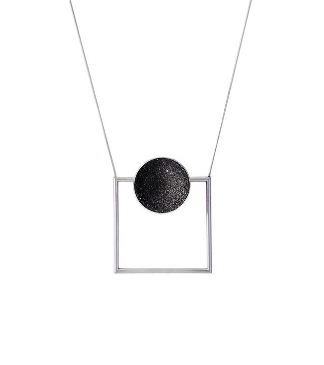 This Bauhaus inspired geometric necklace features a large stainless steel dome lined with the sparkle of diamond dust encrusted concrete and suspended onto steel square frame.