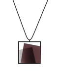 The Astrid necklace in cognac takes its name from Old Norse, meaning “divinely beautiful,” a reflection of its quiet, sculptural presence. Within the square frame, concrete intersects with resin in a deliberate composition that reveals depth and movement. The meeting of materials creates subtle shifts in tone and surface, drawing the eye to the balance between precision and softness. The Astrid necklace embodies refined minimalism with a sense of calm, architectural beauty.