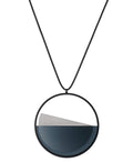 The Clara necklace in cerulean blue embodies clarity and balance. Named from the Latin clarus, meaning “bright” or “clear,” it reflects the quiet harmony of light and material. Within the circular frame, concrete emerges from the surface of the resin, creating a gentle rise in tone and texture. The Clara necklace carries a calm, sculptural presence that feels both modern and enduring.